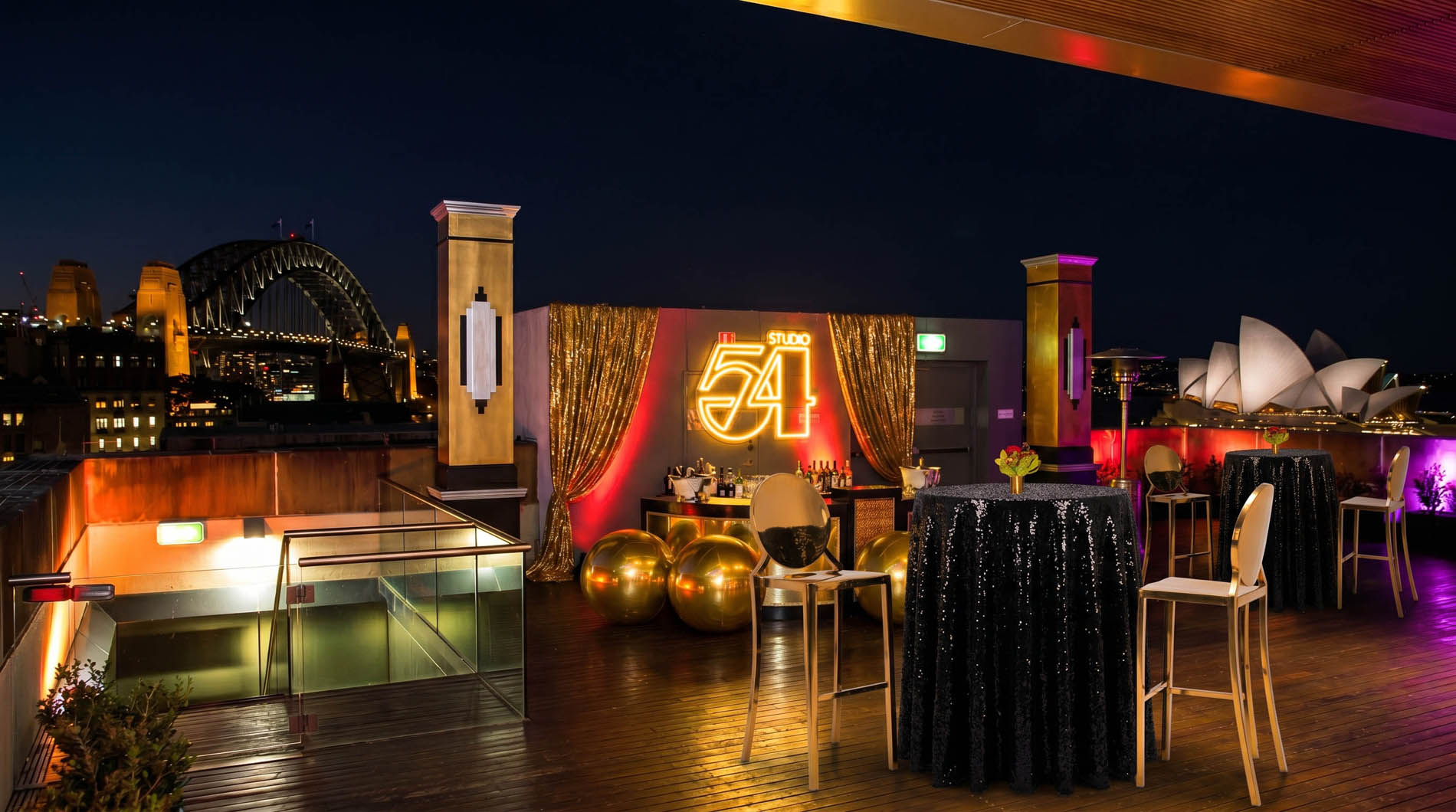Rooftop bar styled with gold orbs and sequin tables overlooking Sydney Harbour Bridge