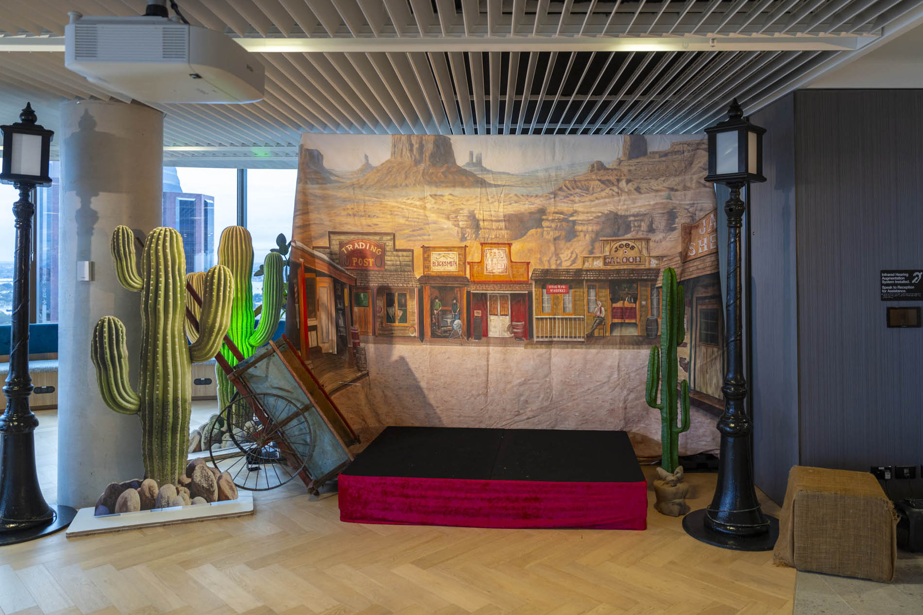 Desert stage set with saguaro cacti, hurricane lanterns, and a painted frontier town backdrop