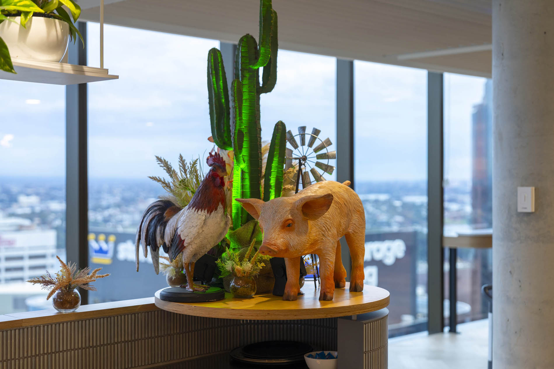 Styled farm animal figures beside illuminated cacti and a windmill