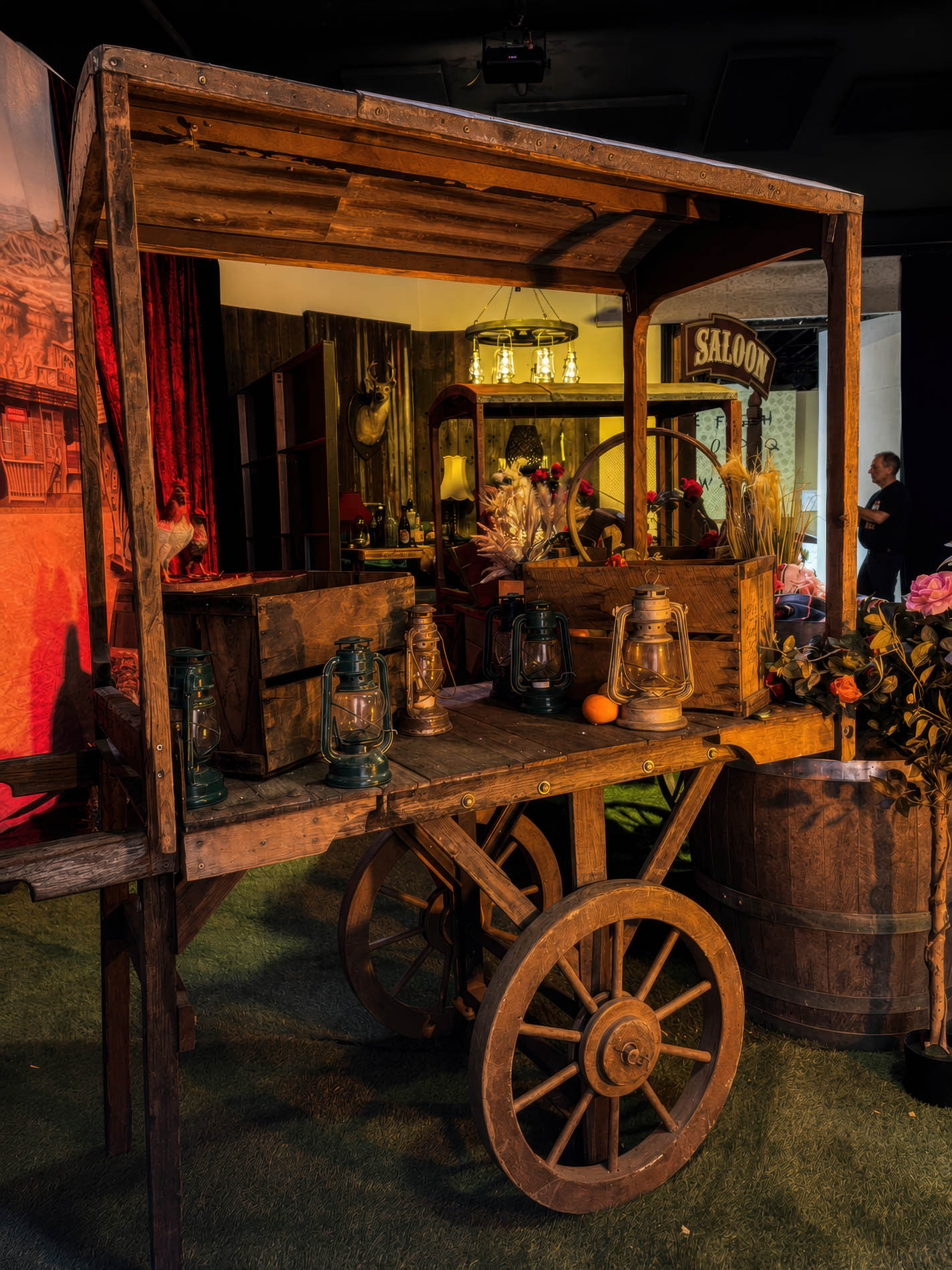 Timber trade cart styled with hurricane lanterns beneath a SALOON sign