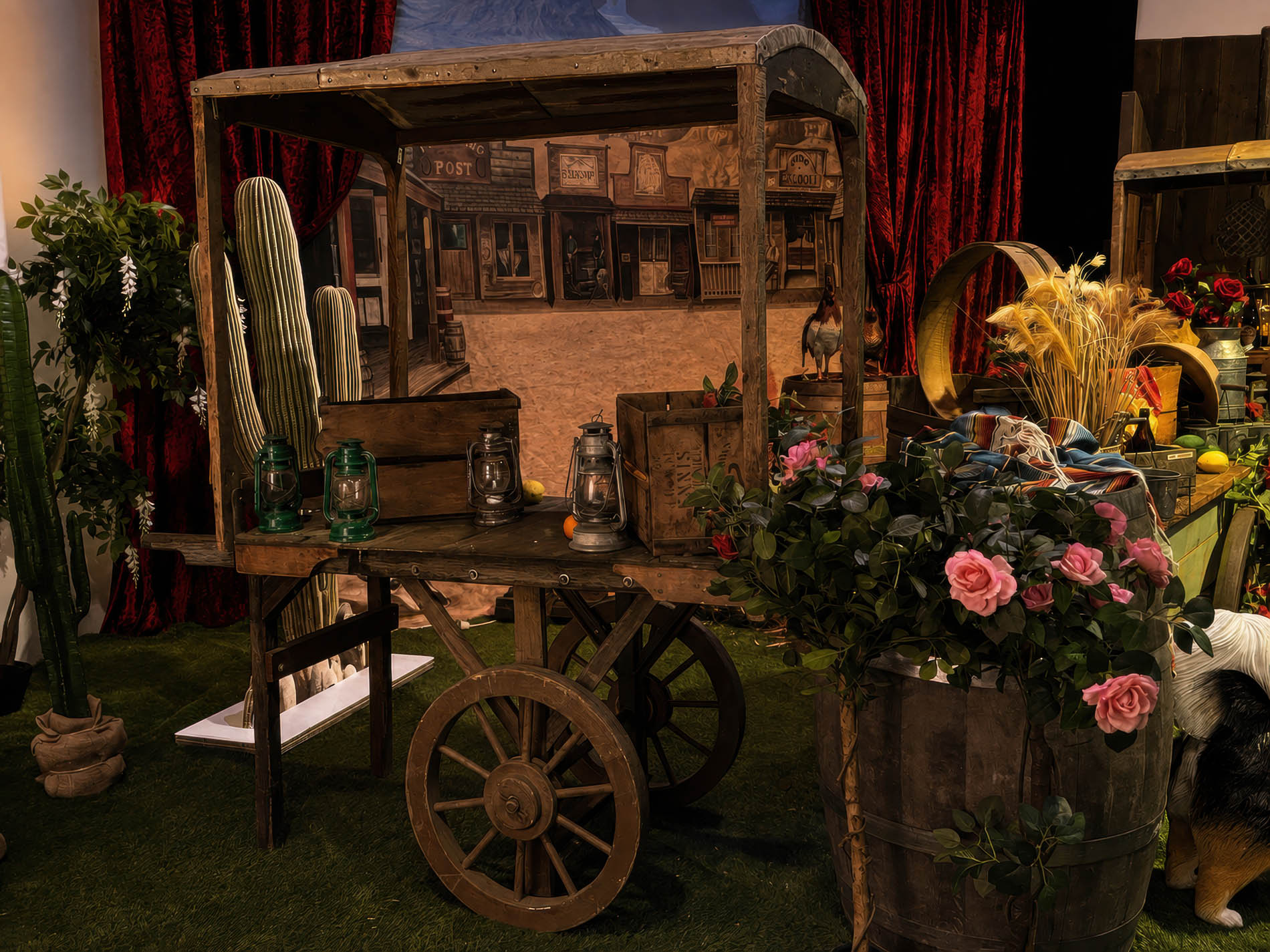 Timber trade cart dressed with roses and red velvet drapes against a painted town backdrop